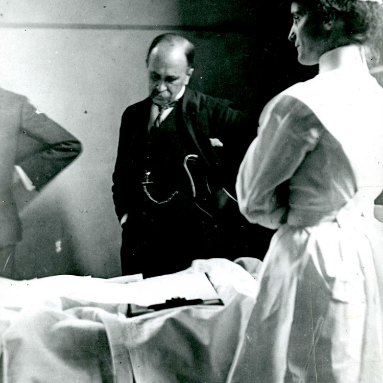 Candid photograph of Osler at approximately 55 years old and a nurse examining a patient.