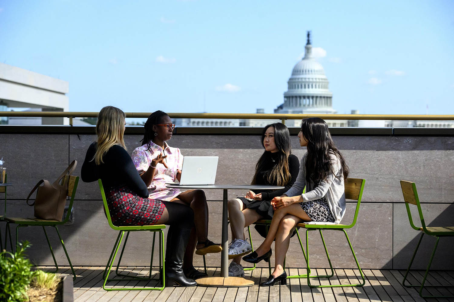 Four students sitting at a table on the roof of the Hopkins Bloomberg Center
