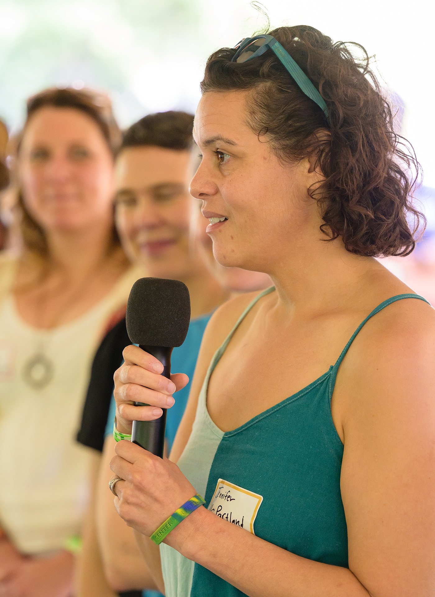 A woman in a green dress talks into a microphone